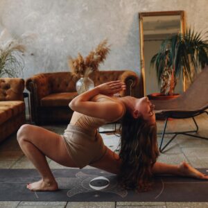 A woman practicing yoga indoors, capturing a moment of calm and flexibility on a yoga mat.